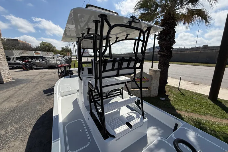 Slide: The Image of 2026 Shallow Sport 25 X3 boat with elevated seating, parked near palm tree. - 12