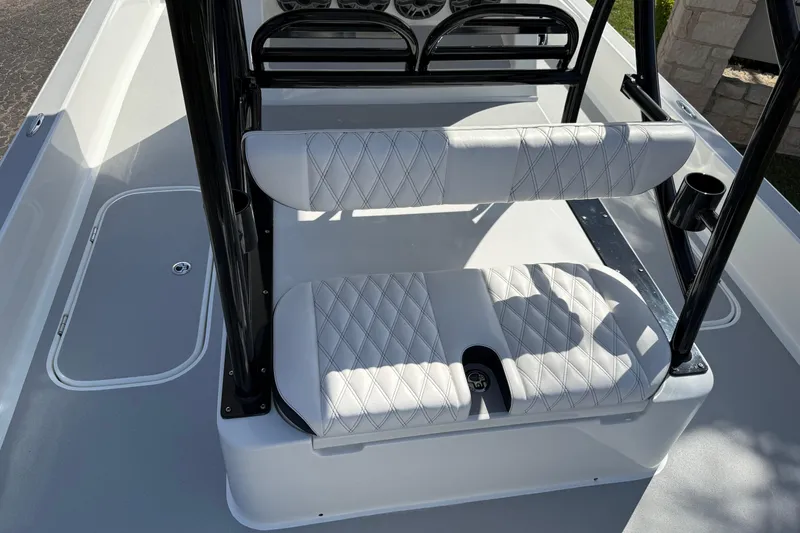 Slide: The Image of 2026 Shallow Sport 25 X3 boat interior with white cushioned seating and black frame. - 14