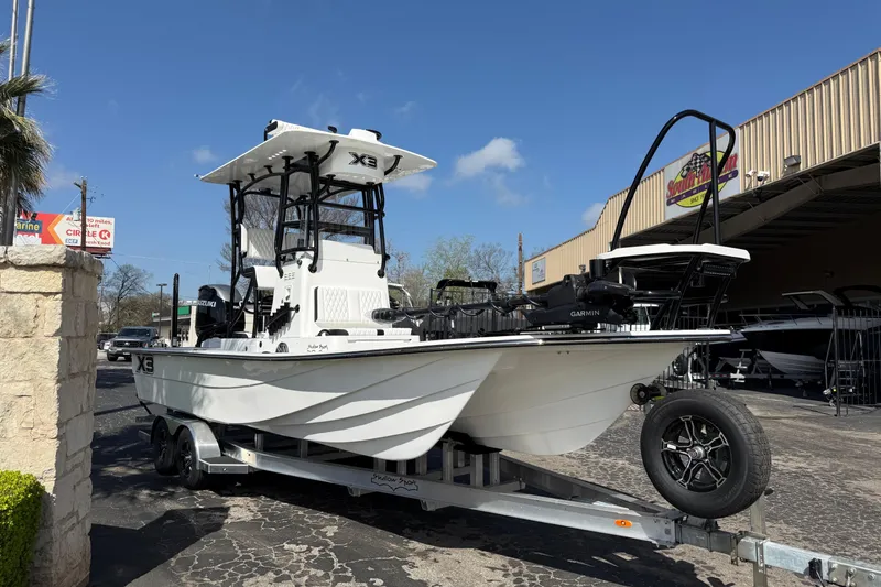 Slide: The Image of 2026 Shallow Sport 25 X3 boat on trailer outside dealership. - 2