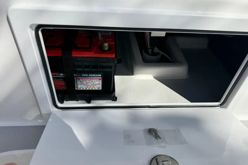 Slide: The Image of Battery compartment of 2026 Shallow Sport 25 X3 boat, featuring secured battery and keys. - 20