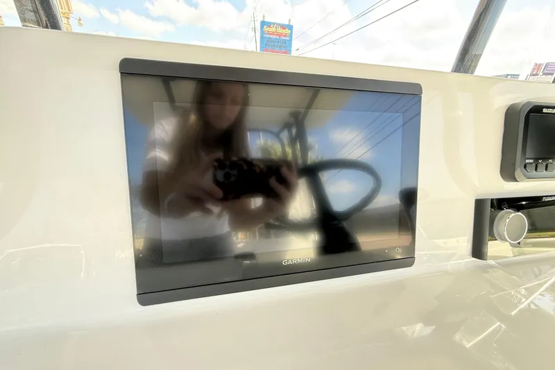 Slide: The Image of Garmin display on 2026 Shallow Sport 25 X3 boat dashboard, reflecting surroundings. - 27