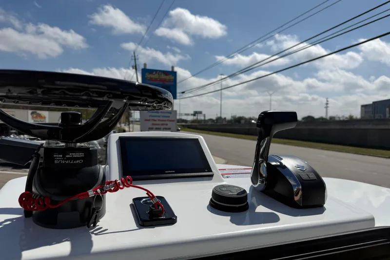 Slide: The Image of 2026 Shallow Sport 25 X3 boat dashboard with steering wheel and controls under a sunny sky. - 39