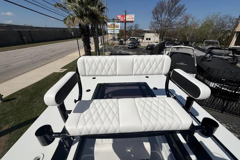 Slide: The Image of 2026 Shallow Sport 25 X3 boat with white cushioned seating and palm trees in the background. - 45