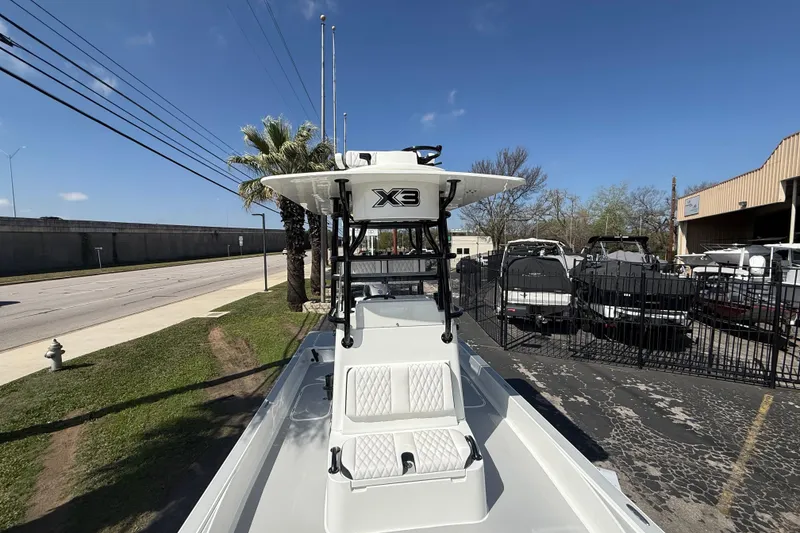 Slide: The Image of 2026 Shallow Sport 25 X3 boat displayed outdoors, featuring sleek design and elevated console. - 49