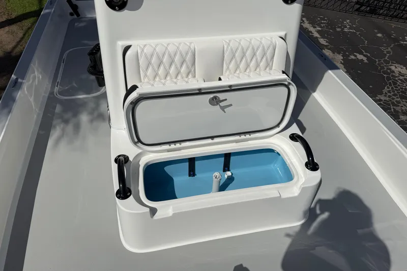 Slide: The Image of Open storage compartment on 2026 Shallow Sport 25 X3 boat with cushioned seating. - 50