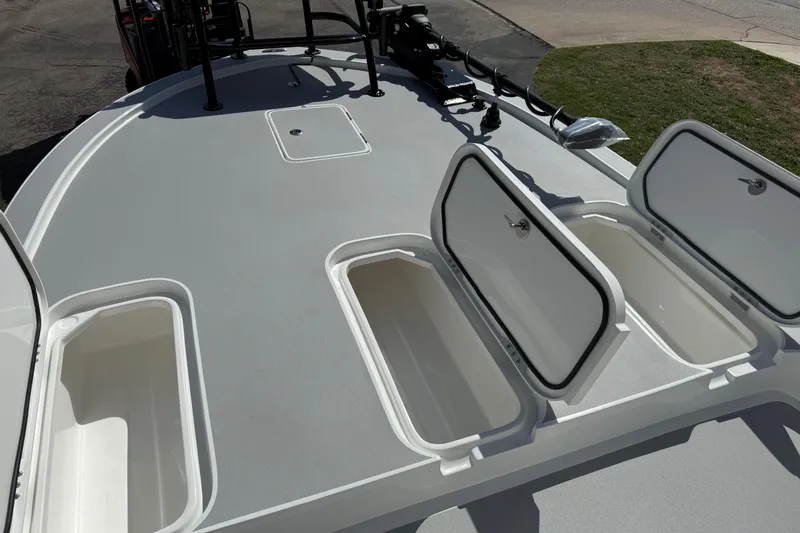 Slide: The Image of 2026 Shallow Sport 25 X3 boat deck with open storage compartments. - 51