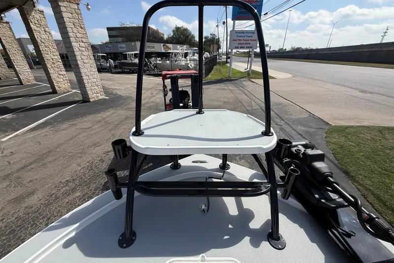 Slide: The Image of 2026 Shallow Sport 25 X3 boat with elevated platform, parked outdoors. - 57