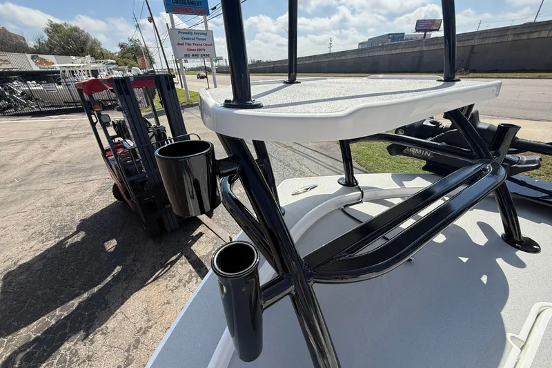 Slide: The Image of 2026 Shallow Sport 25 X3 boat with rod holders and elevated platform, parked outdoors. - 58