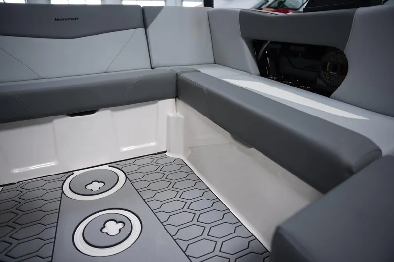 Slide: The Image of Interior of 2025 MasterCraft NXT20 boat with gray seating and hexagonal floor design. - 11