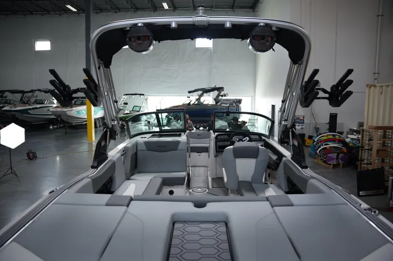 Slide: The Image of 2025 MasterCraft NXT20 boat interior in showroom, featuring modern seating and equipment. - 16