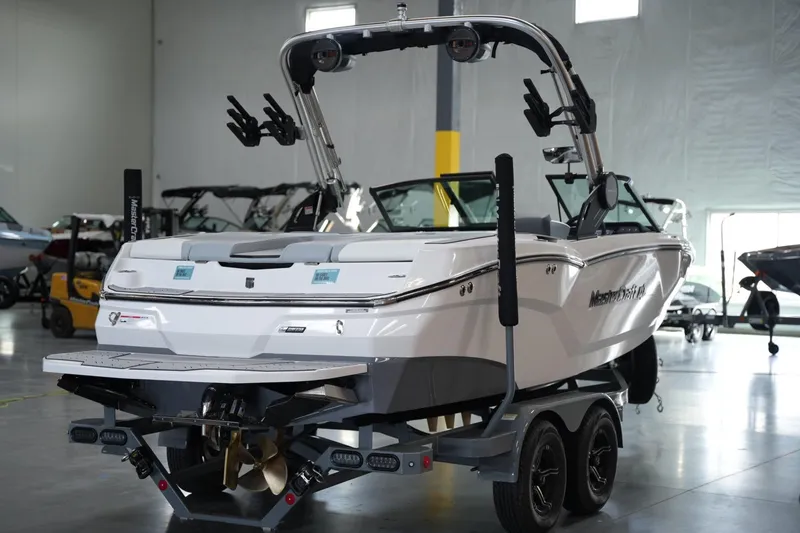Slide: The Image of 2025 MasterCraft NXT20 boat on trailer in showroom, rear view. - 4