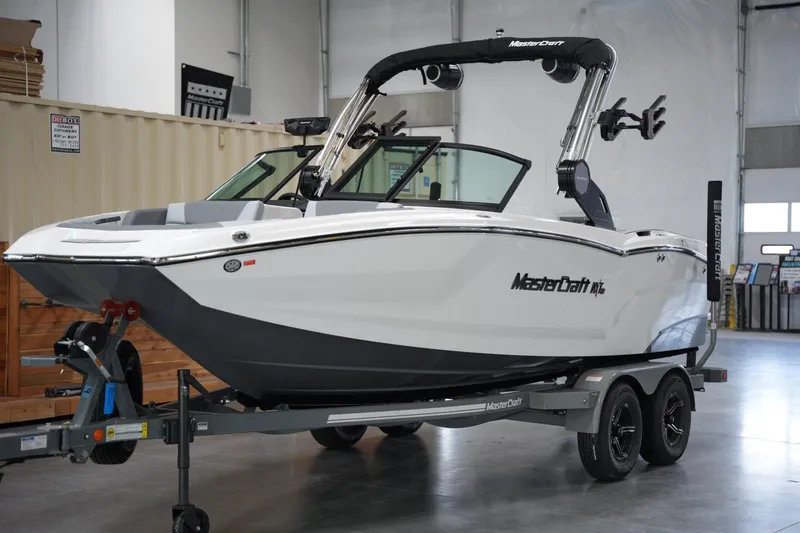 Slide: The Image of 2025 MasterCraft NXT20 boat on trailer in indoor showroom. - 7