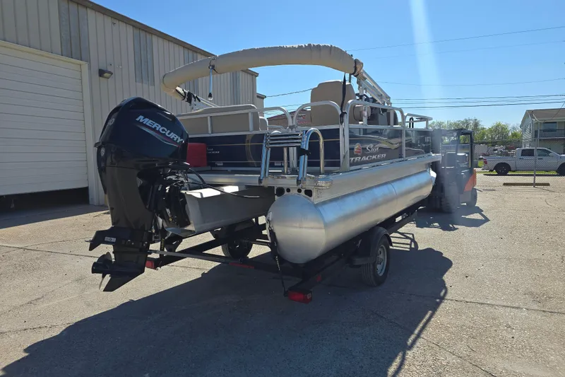 Slide: The Image of 2024 Sun Tracker Bass Buggy 16 XL Select pontoon boat with Mercury engine on trailer. - 4