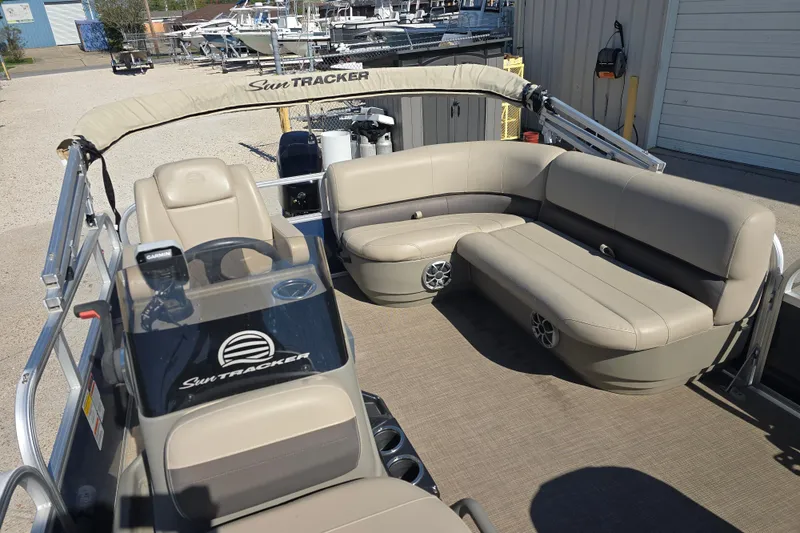 Slide: The Image of 2024 Sun Tracker Bass Buggy 16 XL Select pontoon boat with beige seating and steering console. - 8