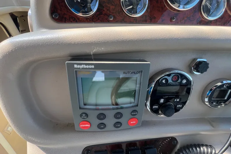 Slide: The Image of 1998 Sea Ray 290 Sundancer dashboard with Raytheon autopilot and Fusion audio controls. - 10