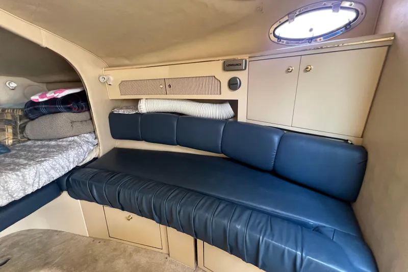 Slide: The Image of 1998 Sea Ray 290 Sundancer cabin interior with blue seating and storage cabinets. - 14