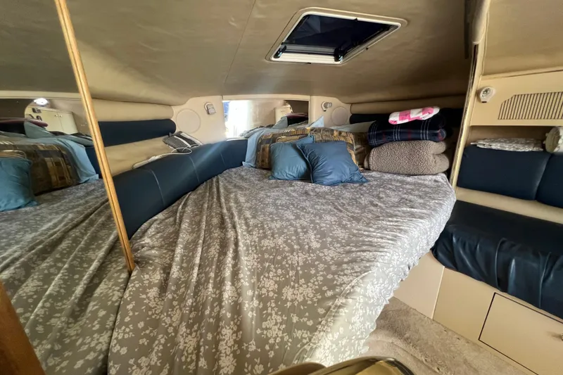 Slide: The Image of Cozy cabin interior of 1998 Sea Ray 290 Sundancer with bed and pillows. - 15