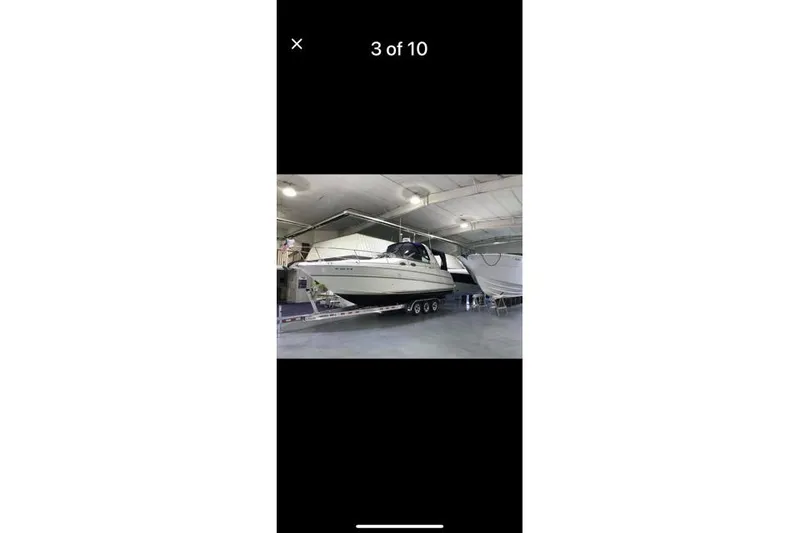 Slide: The Image of 1998 Sea Ray 290 Sundancer boat on trailer in indoor storage facility. - 24