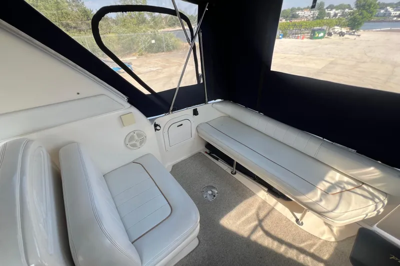 Slide: The Image of Interior view of 1998 Sea Ray 290 Sundancer boat with white seating and carpeted floor. - 4