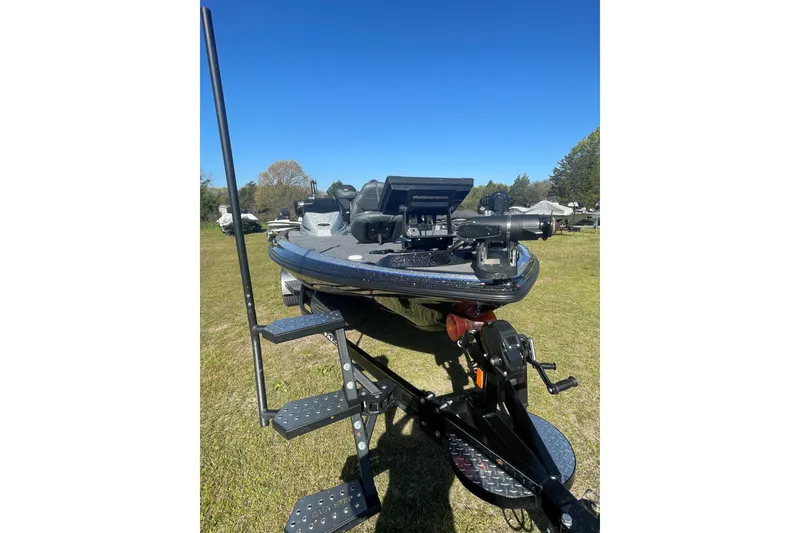 Slide: The Image of 2021 Falcon Boats F20 PREDATOR on trailer, parked on grass under clear blue sky. - 2