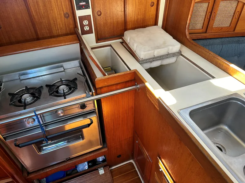Slide: The Image of 1988 Ericson 34 sailboat galley with stove, sink, and storage. - 10