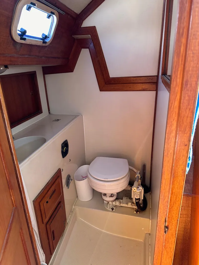 Slide: The Image of 1988 Ericson 34 sailboat bathroom with wooden trim and marine toilet. - 13