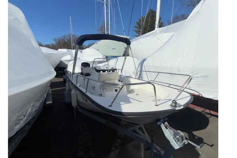 Slide: The Image of 2020 Boston Whaler 170 Montauk boat on trailer, surrounded by covered boats. - 3