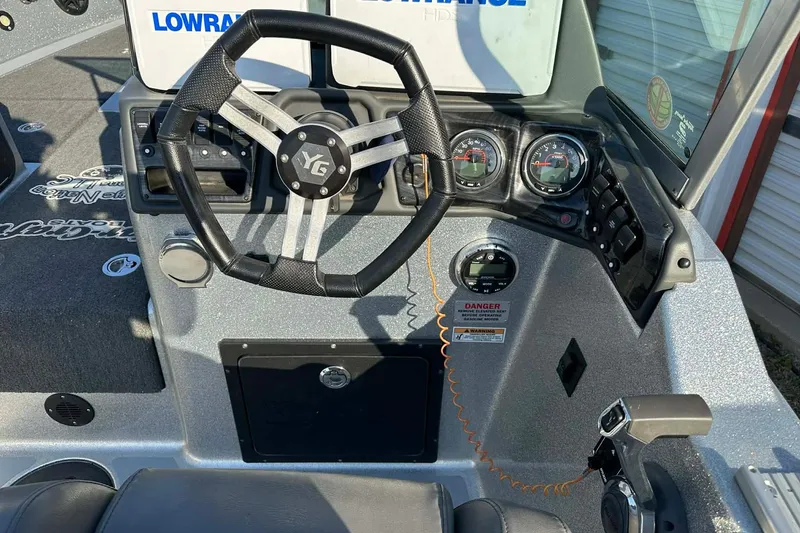 Slide: The Image of 2018 Yar-Craft 219TFX boat dashboard with steering wheel and control panel. - 12