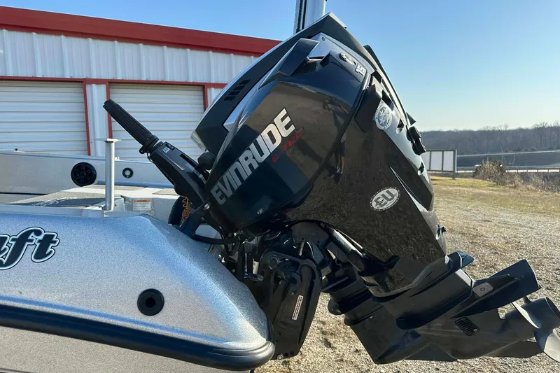 Slide: The Image of 2018 Yar-Craft 219TFX boat with Evinrude engine, parked outdoors near a building. - 24