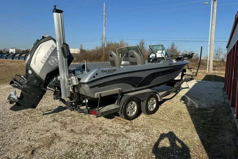 Slide: The Image of 2018 Yar-Craft 219TFX boat on trailer with Evinrude motor, parked outdoors. - 27