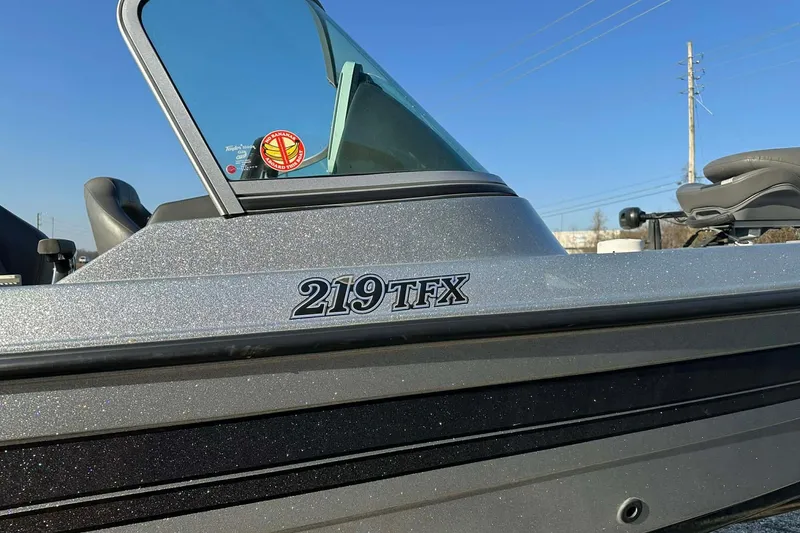 Slide: The Image of 2018 Yar-Craft 219TFX boat with windshield and logo, under clear blue sky. - 43