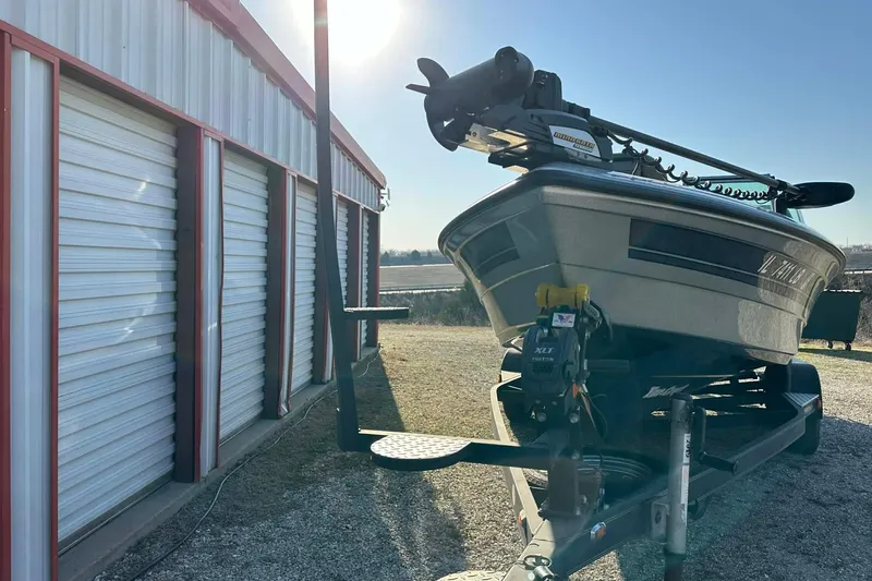 Slide: The Image of 2018 Yar-Craft 219TFX boat parked beside a storage building under bright sunlight. - 50