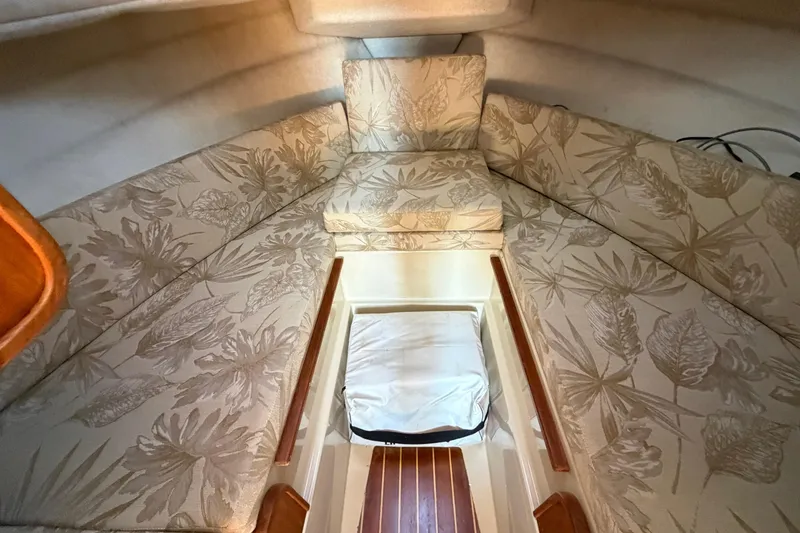 Slide: The Image of 2008 Ranger Tugs R-25 cabin interior with floral-patterned cushions and wooden accents. - 10