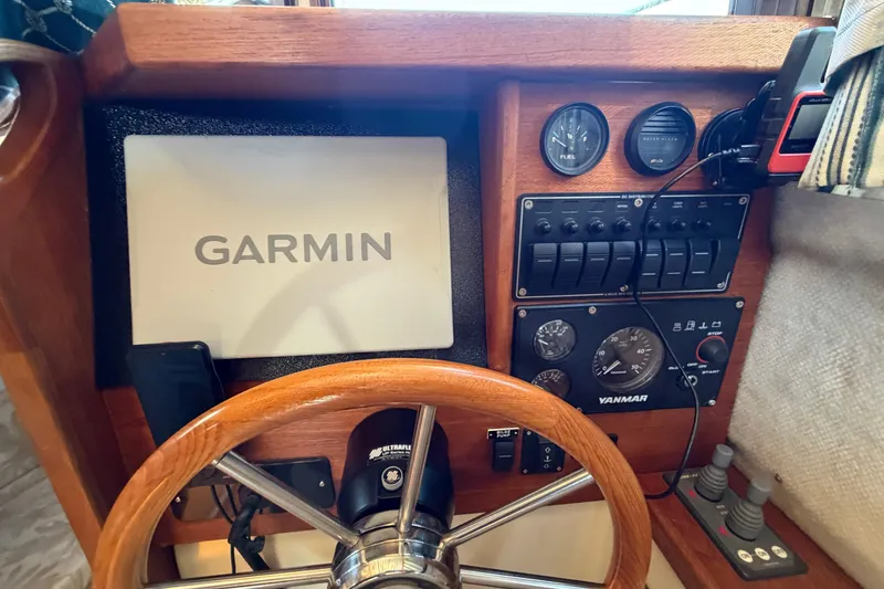 Slide: The Image of 2008 Ranger Tugs R-25 helm with Garmin navigation, gauges, and controls. - 14