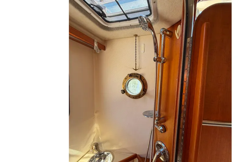 Slide: The Image of Shower area inside 2008 Ranger Tugs R-25 boat with porthole and wooden accents. - 17