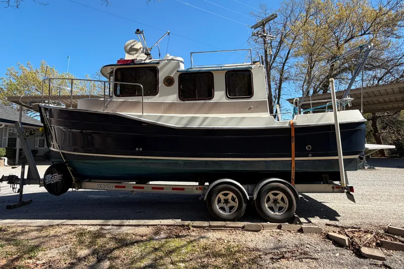 Slide: The Image of 2008 Ranger Tugs R-25 boat on trailer, parked outdoors under clear blue sky. - 4