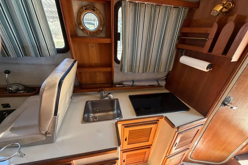 Slide: The Image of Interior of 2008 Ranger Tugs R-25 boat with kitchenette and striped curtains. - 9
