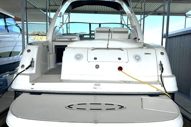 Slide: The Image of 2006 Sea Ray Sundancer 320 yacht docked, rear view showcasing deck and seating area. - 11