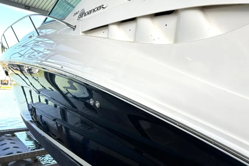 Slide: The Image of 2006 Sea Ray Sundancer 320 yacht docked, showcasing sleek white and blue hull design. - 13
