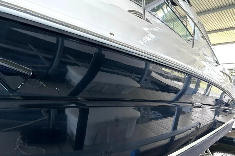 Slide: The Image of 2006 Sea Ray Sundancer 320 yacht with sleek, reflective hull in a covered marina. - 16