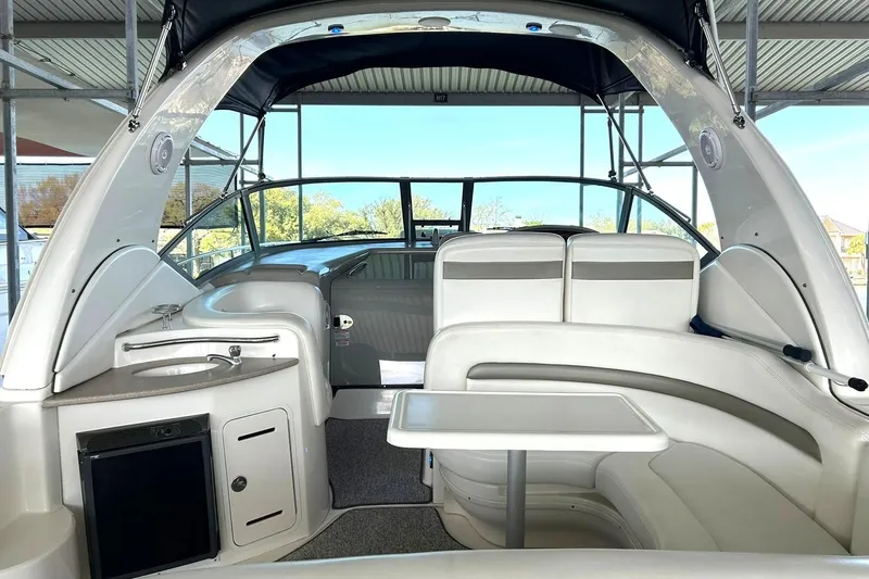 Slide: The Image of 2006 Sea Ray Sundancer 320 interior with seating, table, and kitchenette under a canopy. - 17