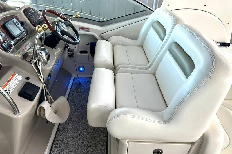Slide: The Image of 2006 Sea Ray Sundancer 320 helm with dual white leather seats and modern controls. - 29
