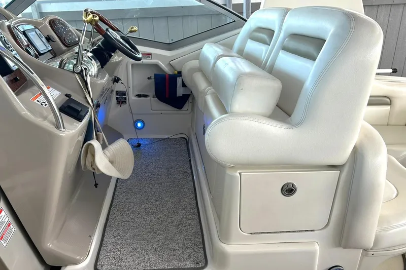 Slide: The Image of Interior of a 2006 Sea Ray Sundancer 320 boat with white seating and steering controls. - 30