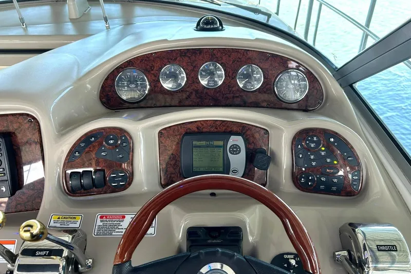 Slide: The Image of Helm of 2006 Sea Ray Sundancer 320 with gauges and controls, featuring wood accents. - 32
