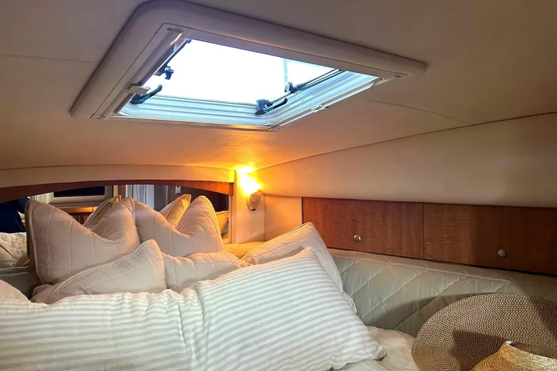 Slide: The Image of Cozy cabin interior of 2006 Sea Ray Sundancer 320 with skylight and plush pillows. - 48
