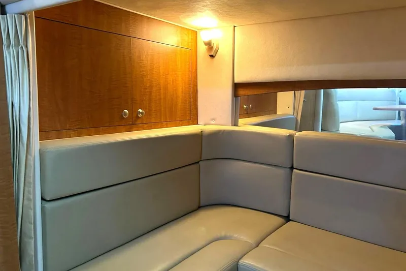 Slide: The Image of Interior of 2006 Sea Ray Sundancer 320, featuring beige leather seating and wooden cabinetry. - 50