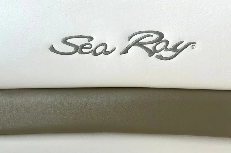 Slide: The Image of Sea Ray logo on 2006 Sundancer 320 boat upholstery, featuring white and beige leather. - 58