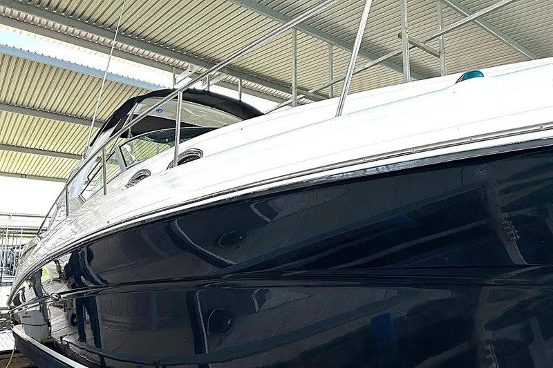 Slide: The Image of 2006 Sea Ray Sundancer 320 yacht under a covered dock, showcasing sleek design. - 61