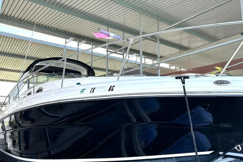 Slide: The Image of 2006 Sea Ray Sundancer 320 yacht docked under a metal roof. - 7