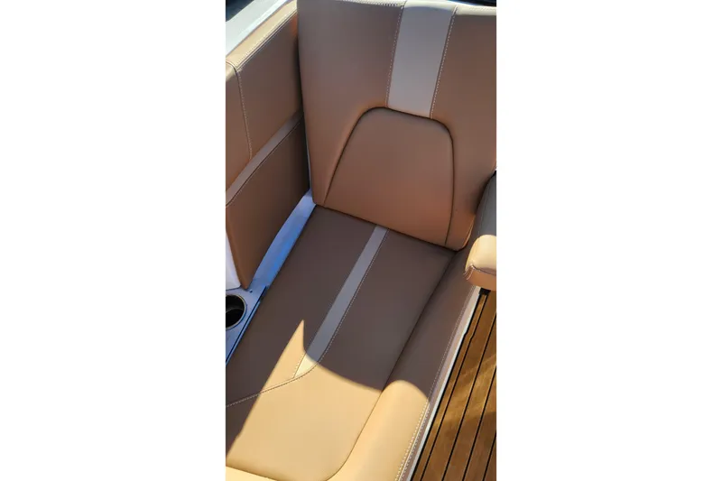 Slide: The Image of 2024 MasterCraft X24 boat seat with tan upholstery and cup holder. - 15